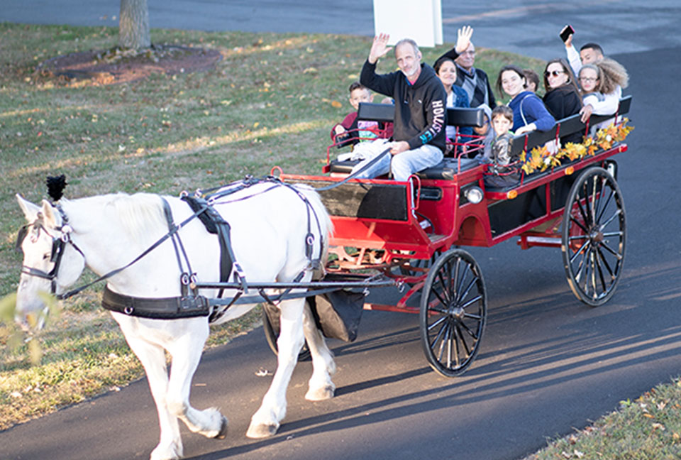 People take a horse carriage ride through the College grounds.