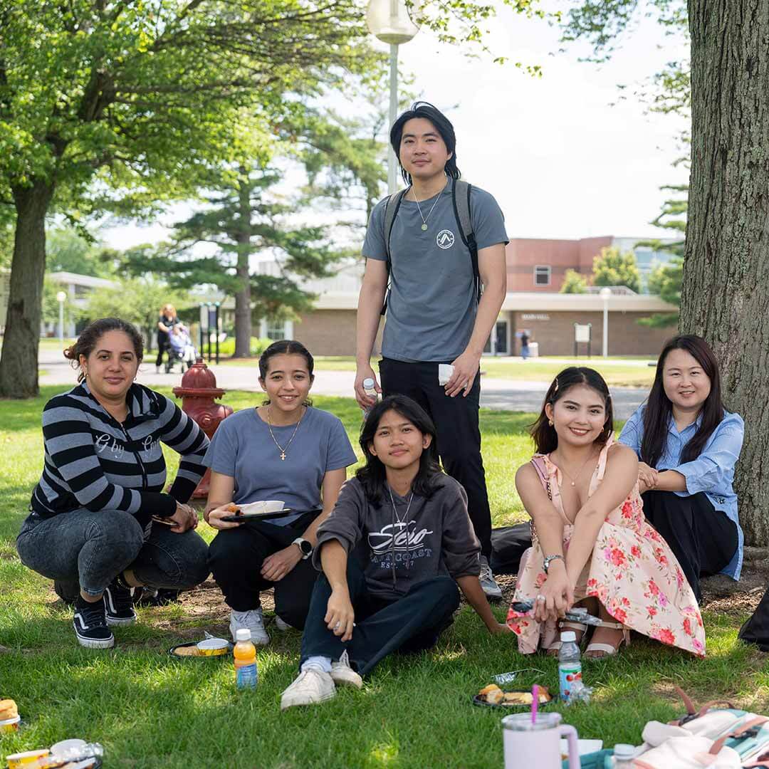 A group gathered under a tree enjoys delicious food at the Juneteenth Brunch.