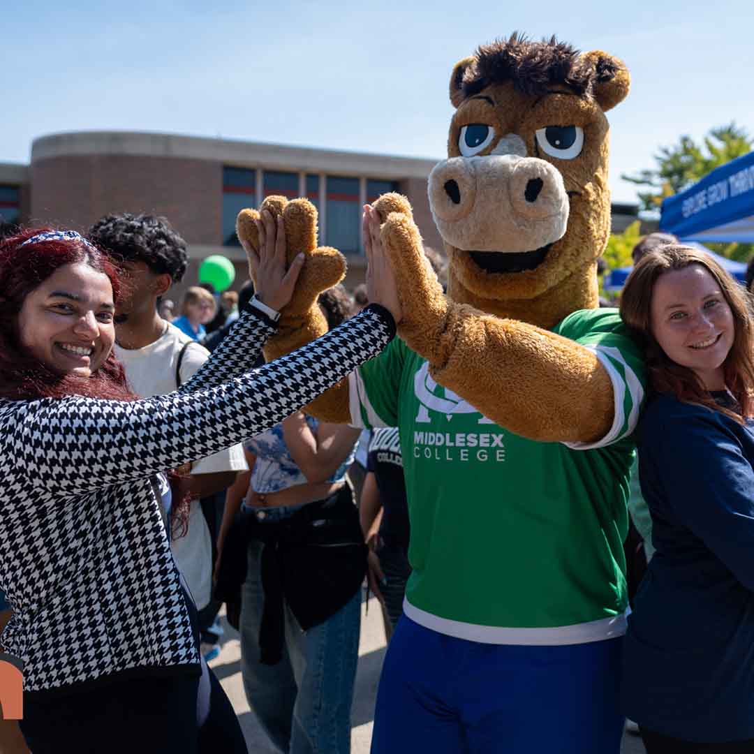 Bolt the Colt high-fives a student.