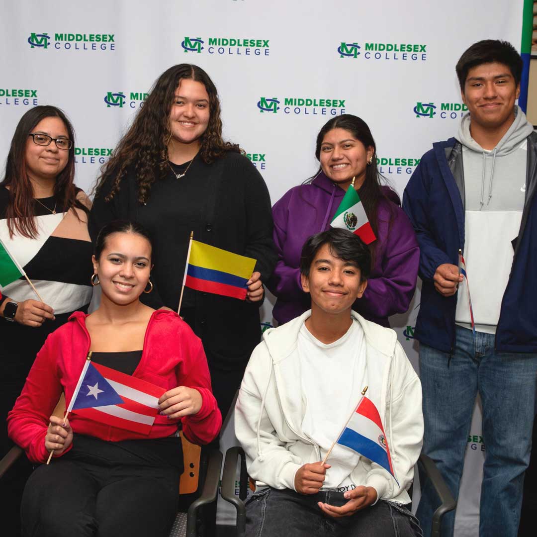 a group of students are holding flags to celbrate Hispanic Heritage Month.