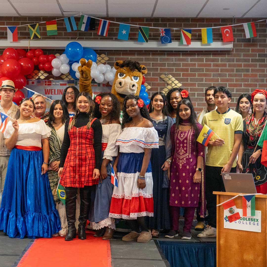 A group of students holding flags of their respective countries.