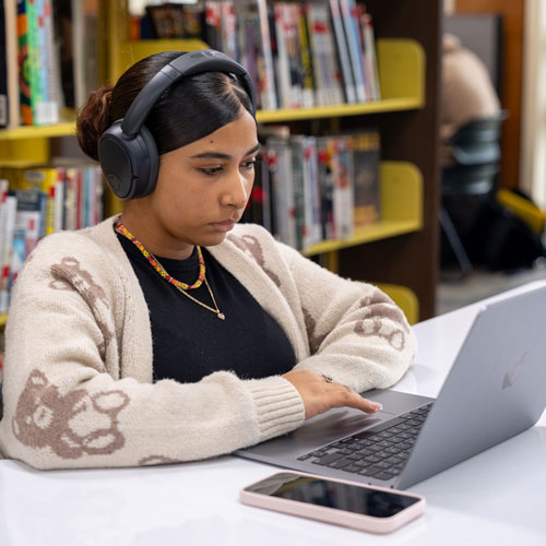 A student focused and studying in the library.