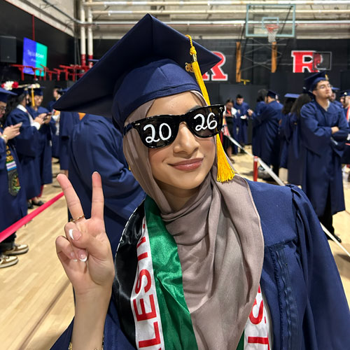 A student on graduation day is wearing sunglasses with 2026 written on the front.
